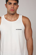 Primer plano de un hombre atlético vistiendo una camiseta sin mangas blanca de tela acanalada. La prenda presenta el texto 'M-DEPARTMENT' en letras negras pequeñas en el lado izquierdo del pecho. El fondo es de un tono gris neutro claro, destacando la textura del tejido y el ajuste atlético de la prenda